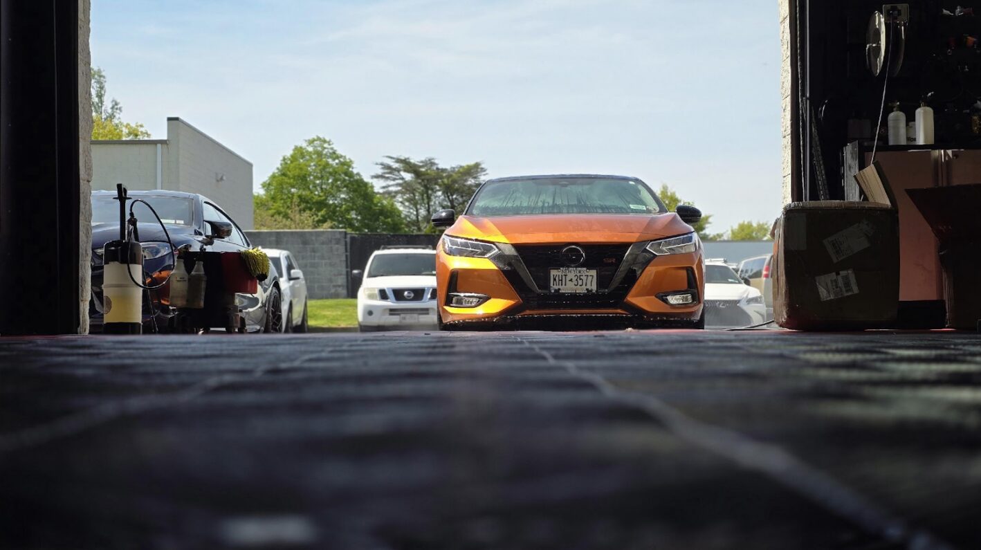 Orange Nissan Sentra SR parked inside a garage bay | ppf in Long Island | Li Car Guys